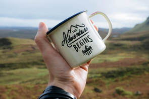The Adventure Begins cup with mountains in background